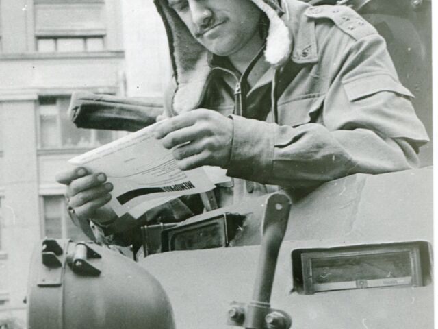 Ein Panzerfahrer, der einen von Memorial herausgegebenen Handzettel liest